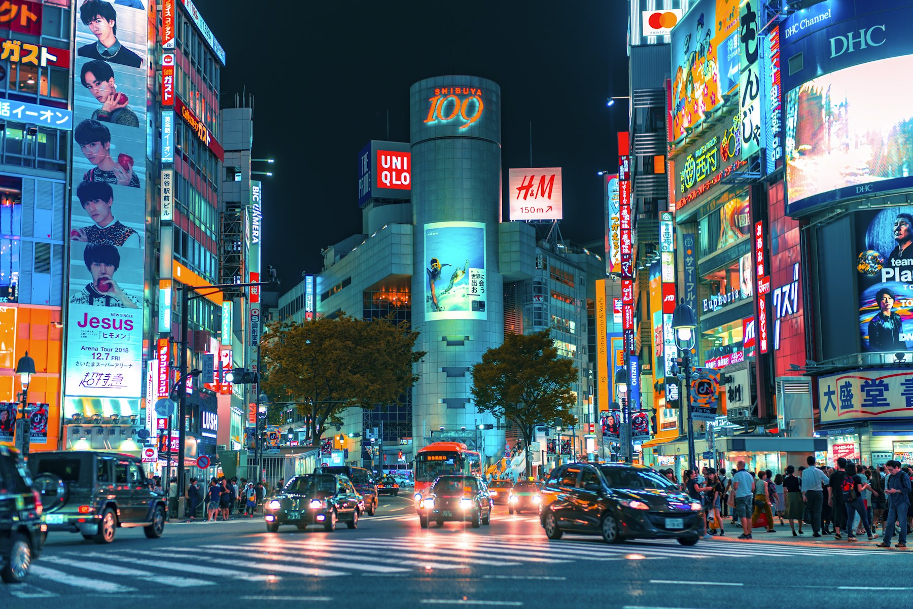 Neon signs and pedestrians on a lively Tokyo street at night